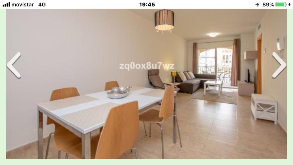 een eetkamer en een woonkamer met een witte tafel en stoelen bij Estepona port in Estepona