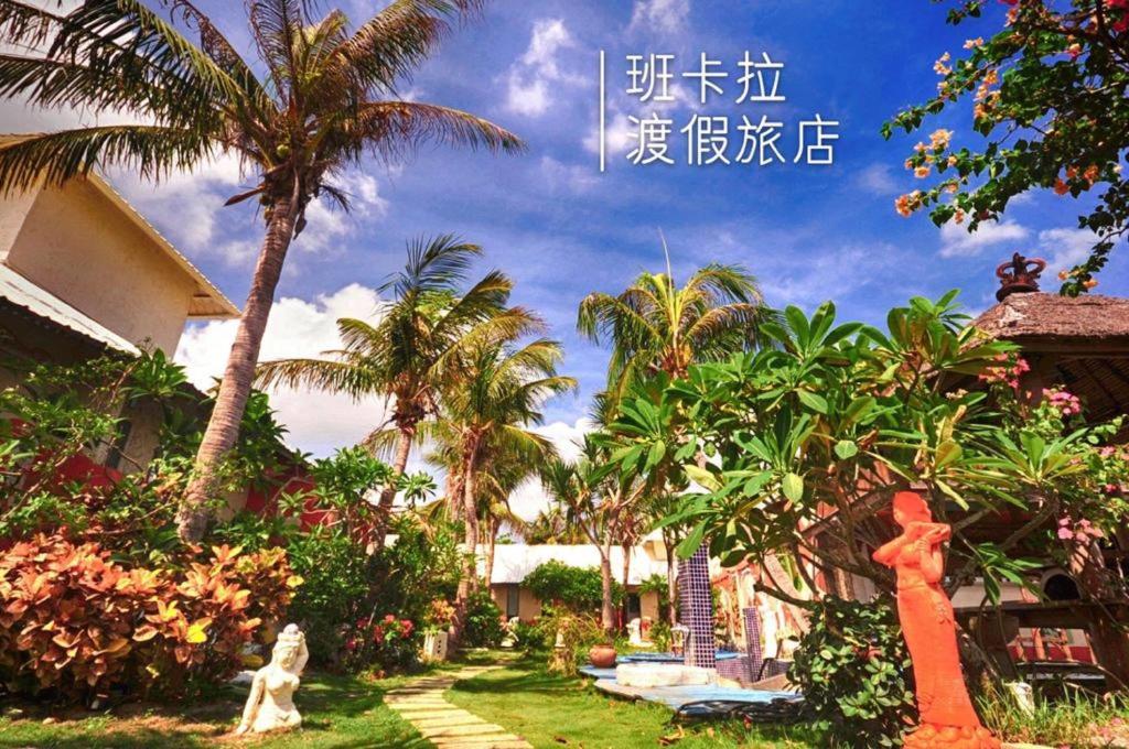 póster de un jardín con palmeras y un perro en Pancala Vacation Inn, en Nanwan