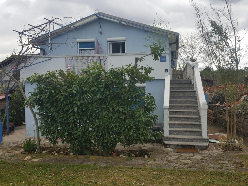 a blue house with stairs in front of it at Rooms and Apartments V&M in Umag