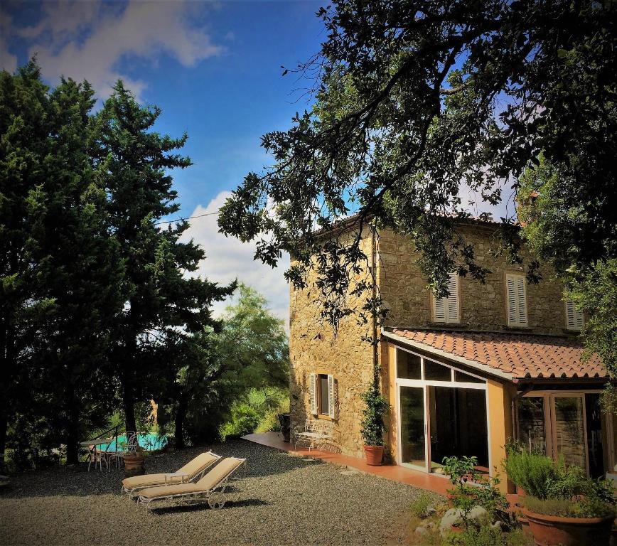 a house with a chair in front of it at La Locanda del Barbagianni in Santa Luce