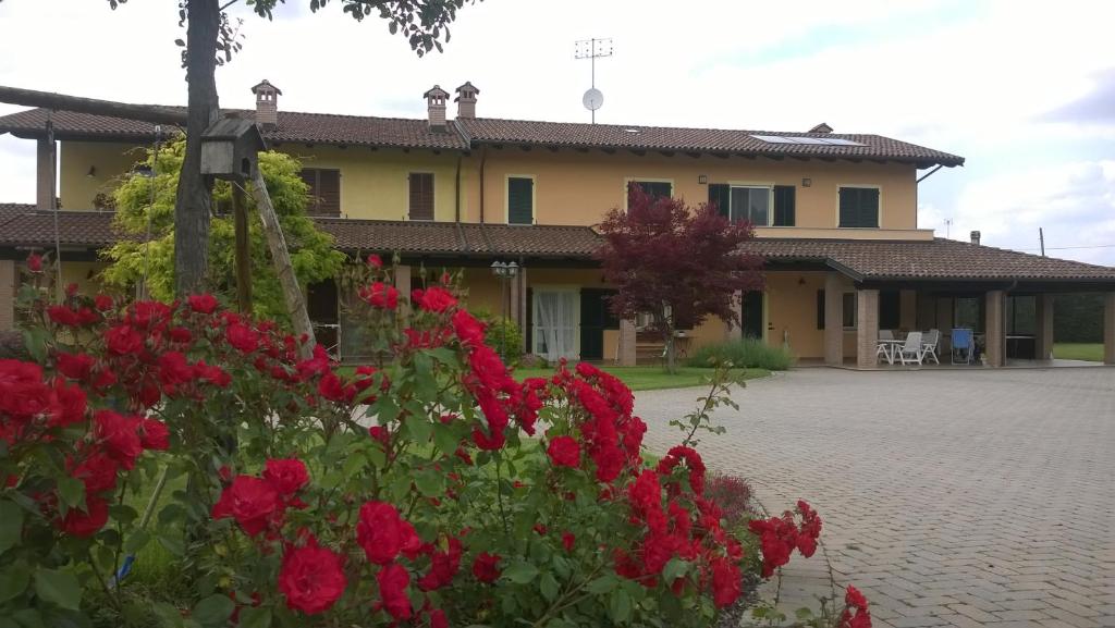 a house with red flowers in front of it at ACERO ROSSO in Pianfei