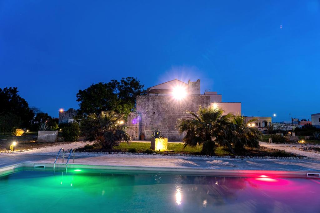 a swimming pool in front of a building at night at CASINO de VITI - Dimora storica con piscina in Vaste