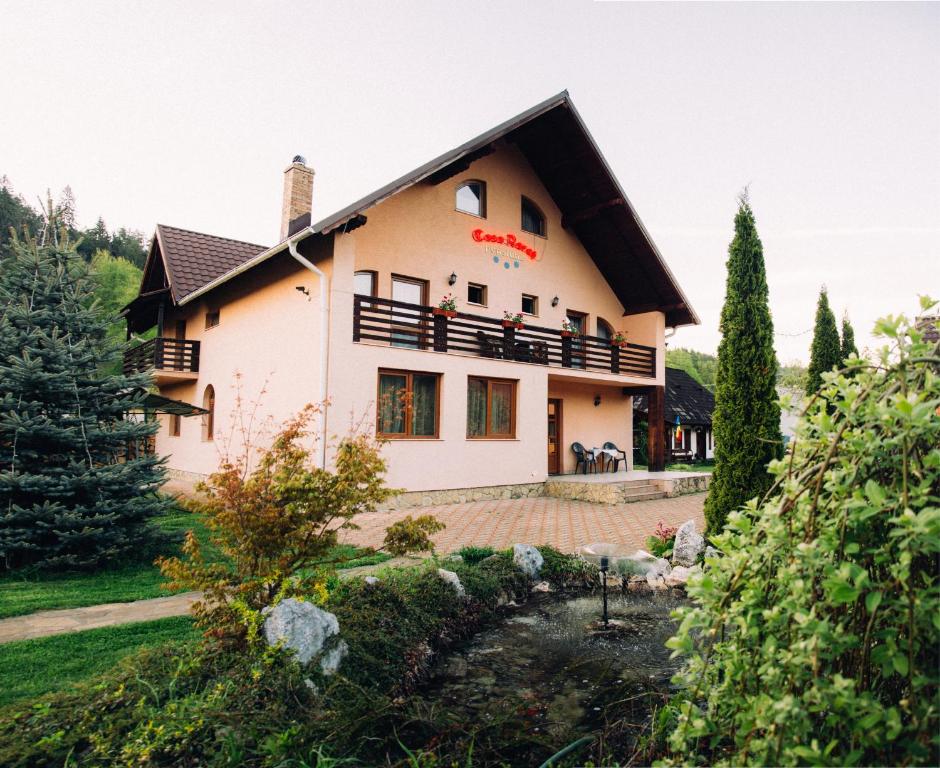 ein großes weißes Haus mit schwarzem Dach in der Unterkunft Casa Rareş Suceviţa in Suceviţa