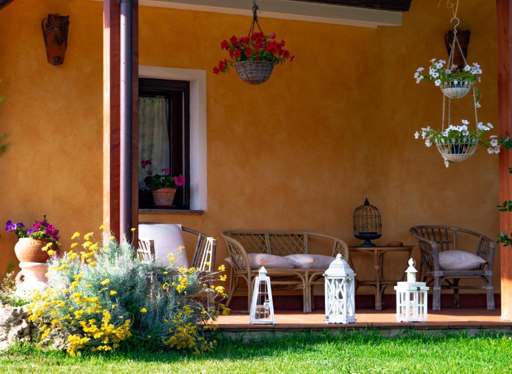 une terrasse couverte d'une maison ornée de fleurs et de plantes dans l'établissement Agriturismo La Genziana, à Alghero