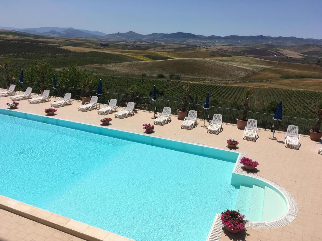 a swimming pool with lounge chairs and a view at Agriturismo Sirignano Wine Resort in Sirignano