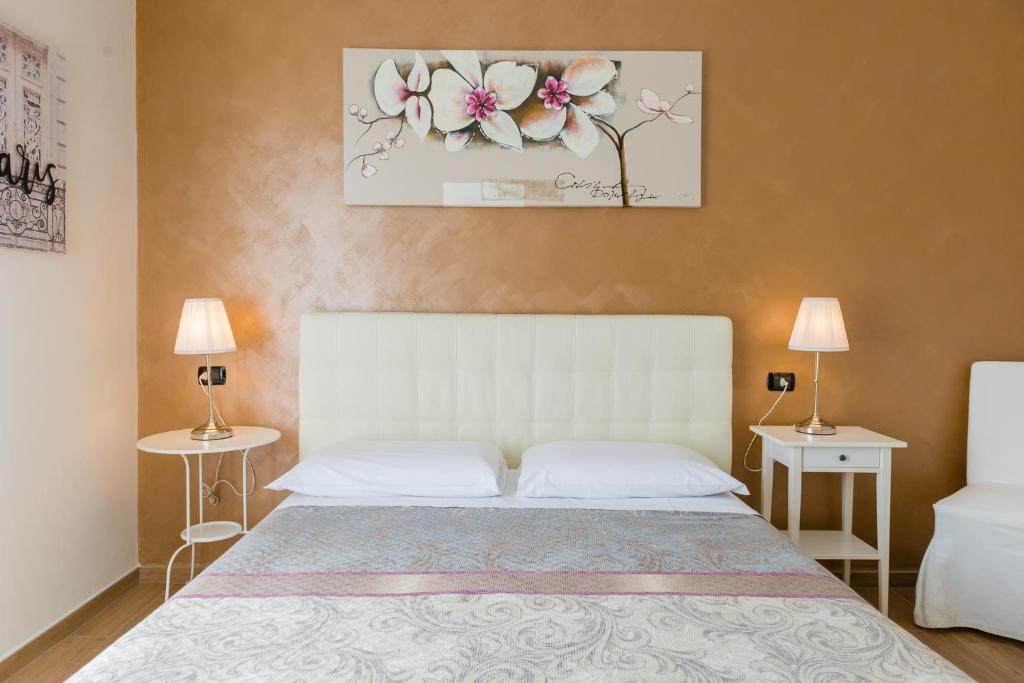 sypialnia z białym łóżkiem z dwoma stołami i dwoma lampami w obiekcie B&B Le City w mieście Montesilvano
