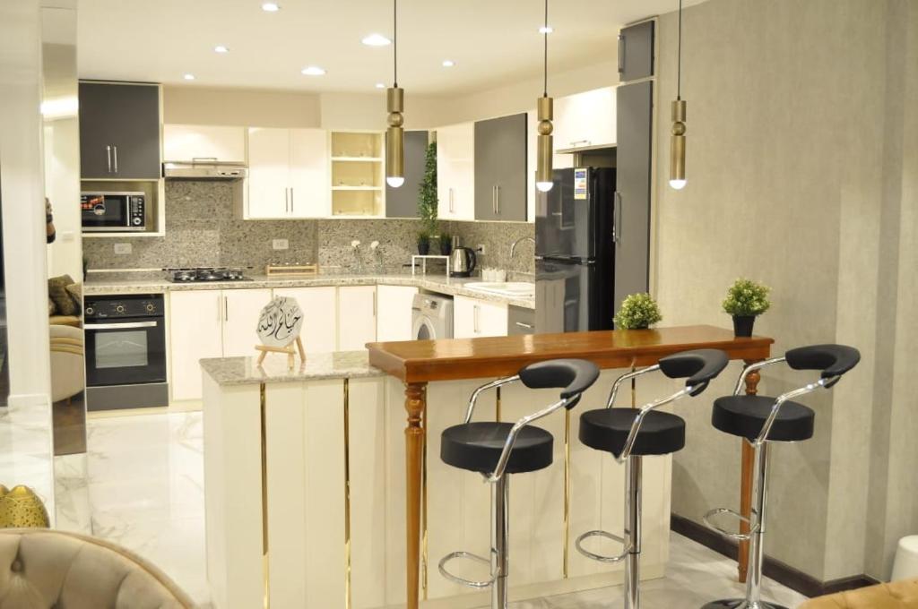 a kitchen with a island with bar stools at Apartment in Mohandesin (Families Only) in Cairo