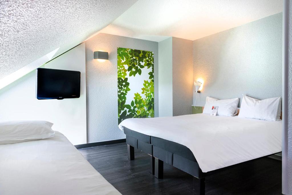 A bed or beds in a room at ibis Strasbourg Sud La Vigie