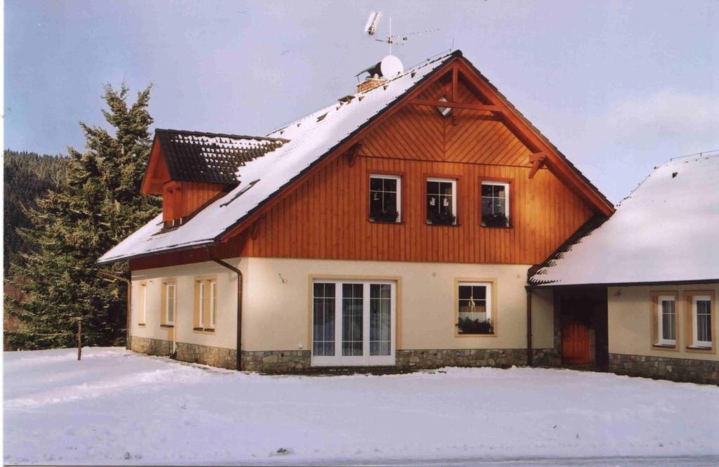 una casa con nieve en el techo en Apartman 300 en Janske Lazne