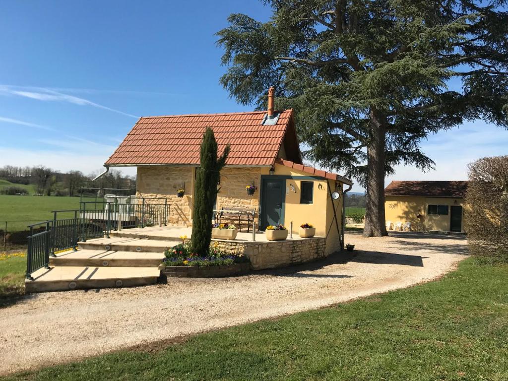 een klein huis met een boom en een oprit bij Domaine BORCHAMPS. in Saint-Nizier-sous-Charlieu