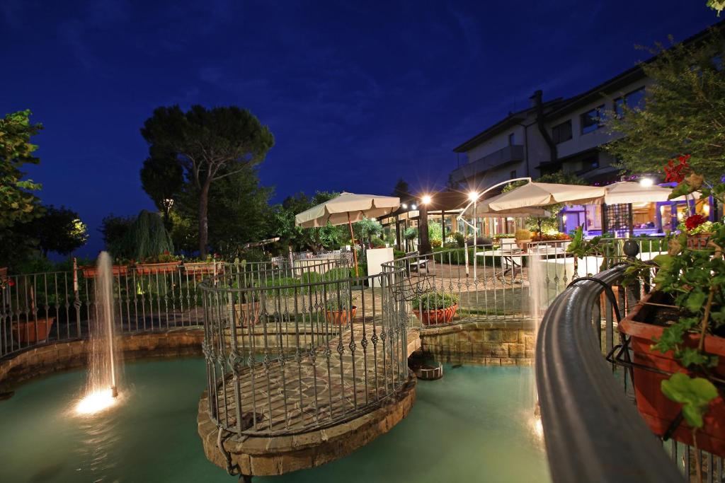 un parque acuático por la noche con una fuente de agua en Hotel Tetto delle Marche - Ristorante dei Conti, en Cingoli