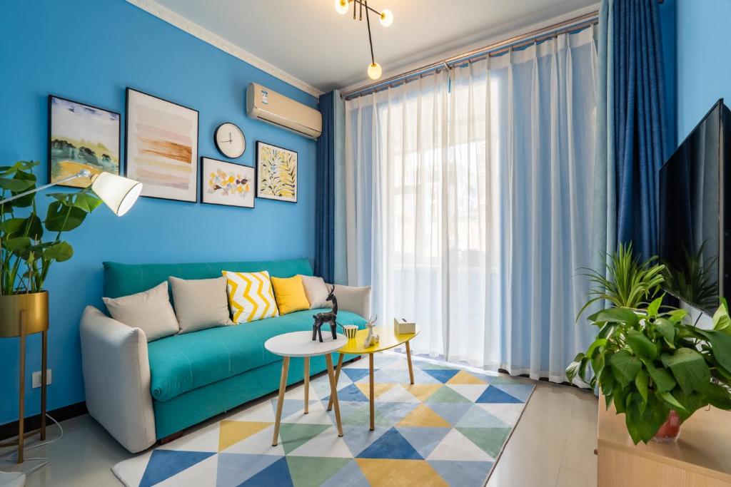uma sala de estar azul com um sofá e uma mesa em Zhengzhou Huiji·Province Sport Centre· Locals Apartment 00161400 em Zhengzhou