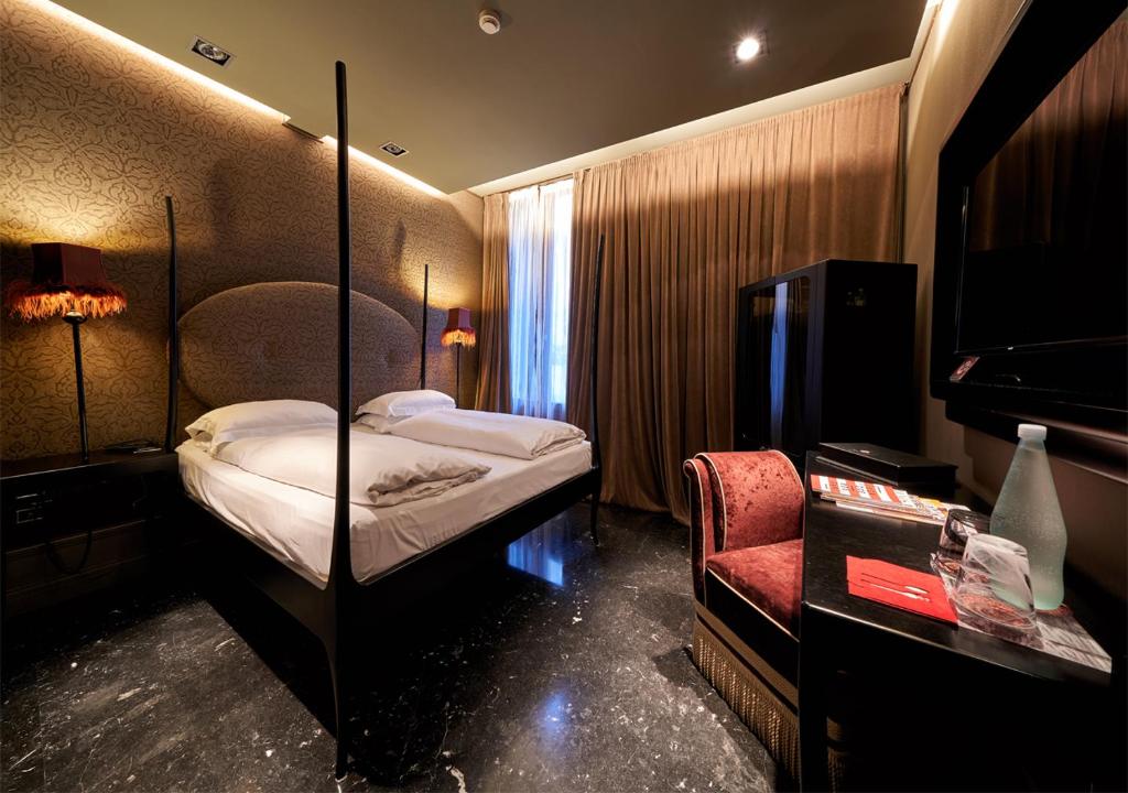 a hotel room with a bed and a chair at Hotel Palazzo Barbarigo Sul Canal Grande in Venice