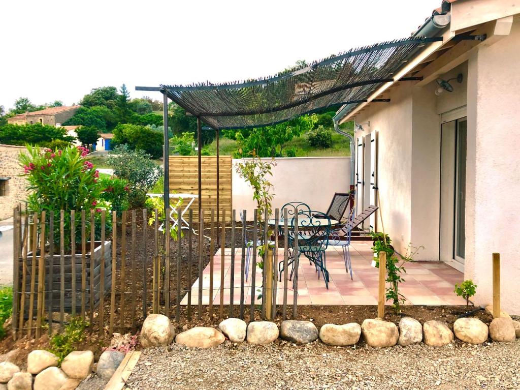 a fence with a table and chairs on a patio at Chez Georges - Maison 2 - Les Gîtes du Verdon in Esparron-de-Verdon