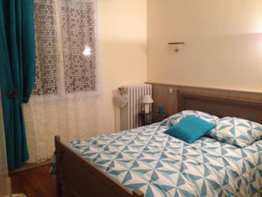 - une chambre avec un lit doté d'un oreiller bleu dans l'établissement le Jardin d'Odette, à Yèvres-le-Petit