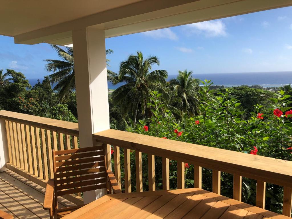 a porch with a bench and a view of the ocean at Pacific views, tranquil location, large home Navy House 2 in Rarotonga