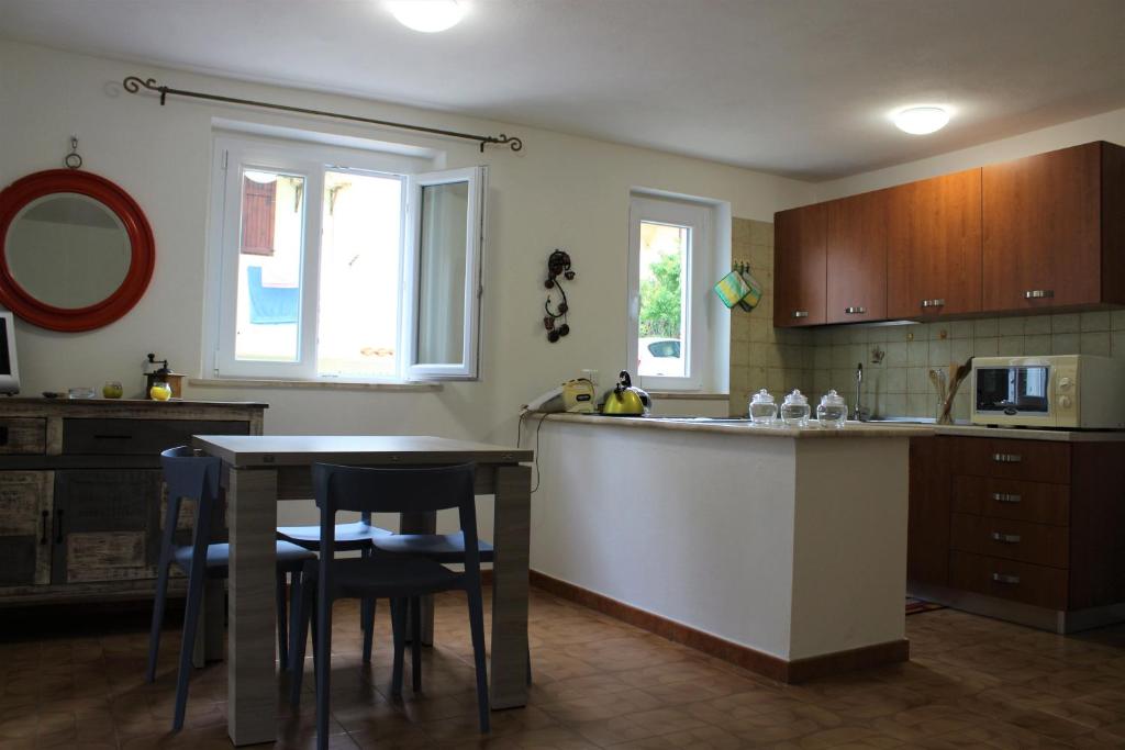 a kitchen with a counter and a table with chairs at La casa di Matilde IUN P2341 in Cala Gonone