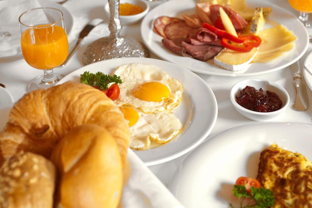 a white table topped with plates of breakfast foods at Hotel Edelweiss & Gurgl in Obergurgl