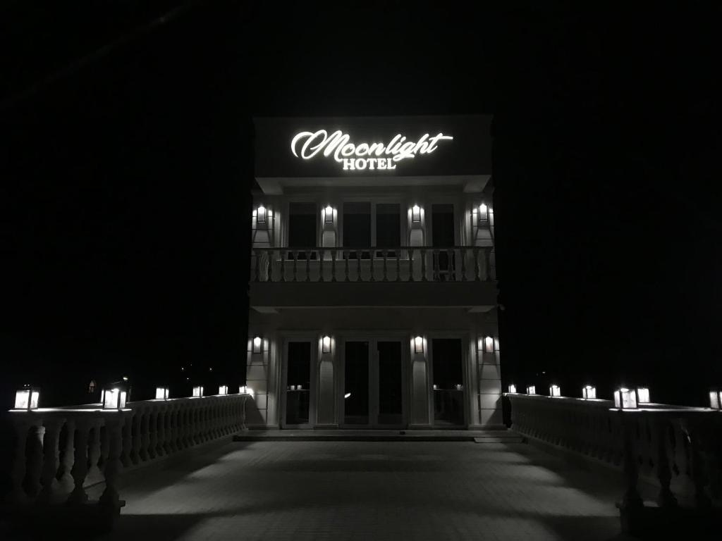 a night view of a hotel with a sign on it at Moonlight Hotel in Chişinău