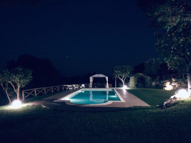 una piscina en medio de un patio por la noche en B&B La Foresteria, en Osimo