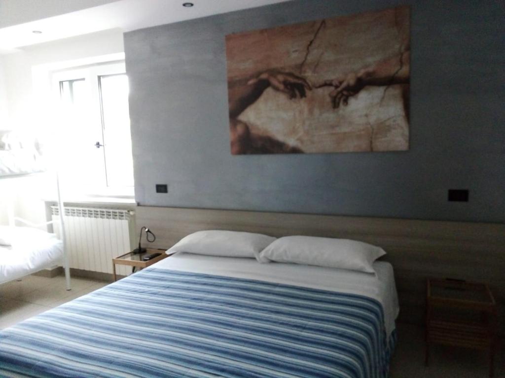 1 dormitorio con 1 cama y una pintura en la pared en Osteria dell'Americano en Potenza