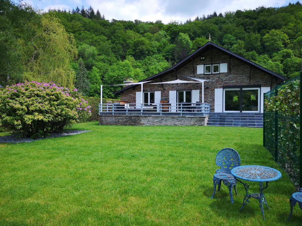 einen Tisch und Stühle vor einem Haus in der Unterkunft La Semois Et Moi in Rochehaut