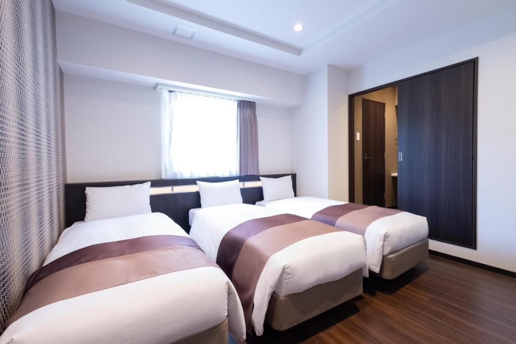 Postel nebo postele na pokoji v ubytování Nipponbashi Luxe Hotel
