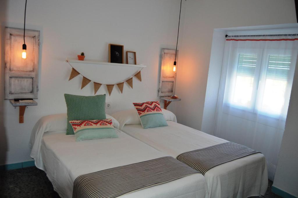 a bedroom with two beds and a window at PENSION SOCAIRE CONIL in Conil de la Frontera