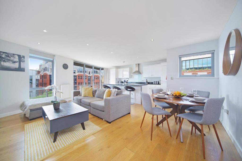 a living room and kitchen with a table and chairs at 2 Bed Executive Penthouse near Liverpool Street FREE WIFI by City Stay Aparts London in London