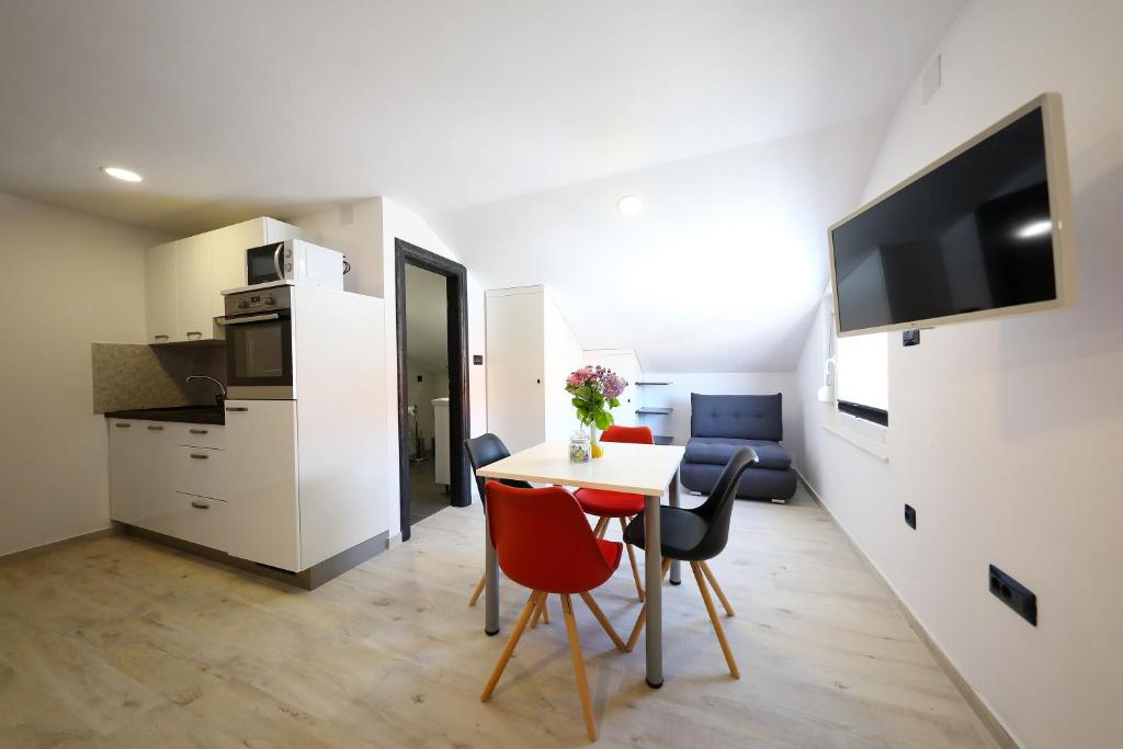 sala de estar con mesa y sillas y cocina en Apartman Sofia, en Zadar