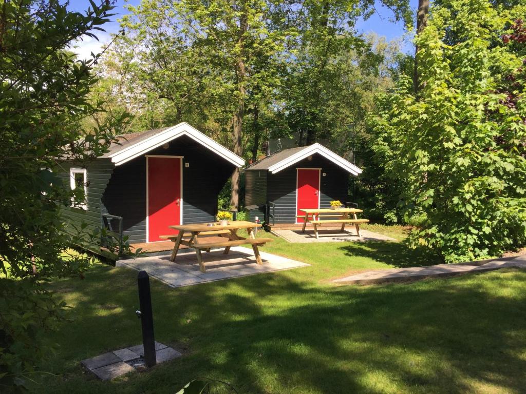 two lodges with a picnic table in the grass at Camping Engelbert (Groningen) in Groningen