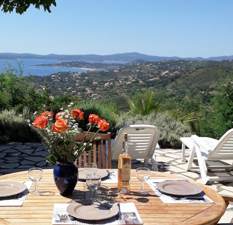 une table en bois avec un vase de fleurs dessus dans l'établissement Beautiful gulf of St Tropez Mazet with large terrace, private area (swimming pools, tennis), à Roquebrune-sur Argens