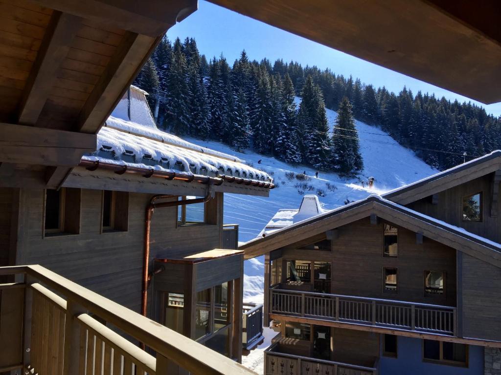 a view from the balcony of a ski lodge with snow covered trees at les 7 laux immobilier chalet E in Prapoutel