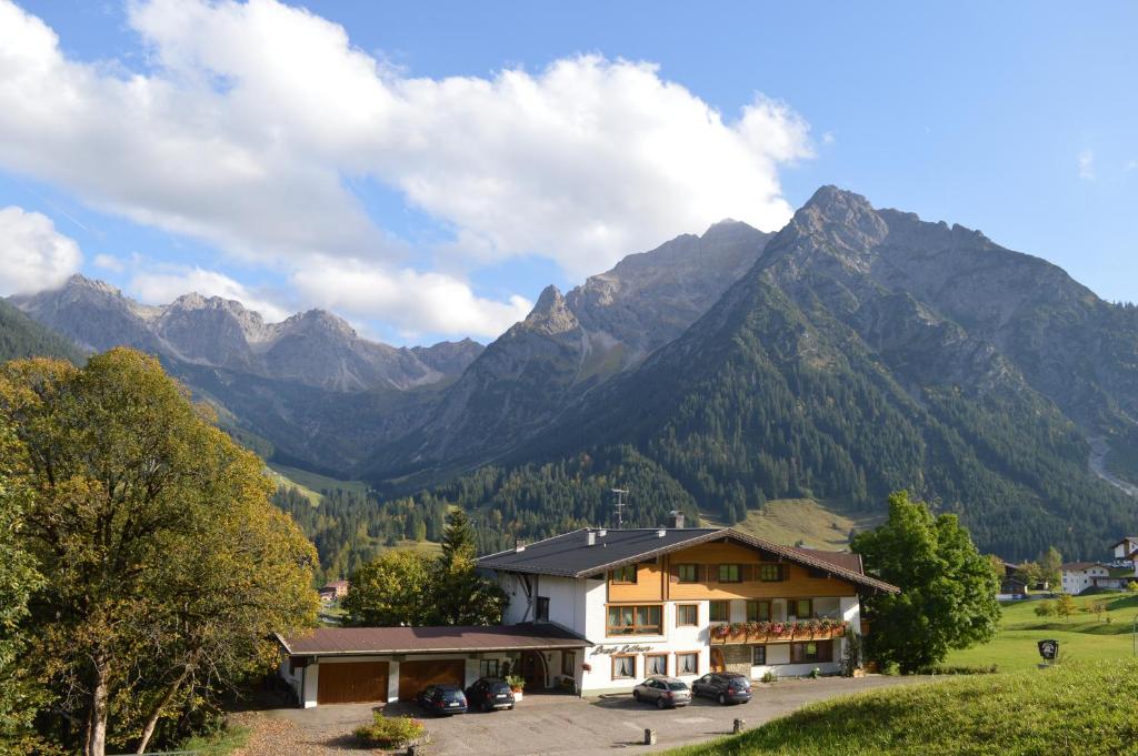 un bâtiment en face d'une chaîne de montagnes dans l'établissement Haus Garni Luggi Leitner, à Mittelberg
