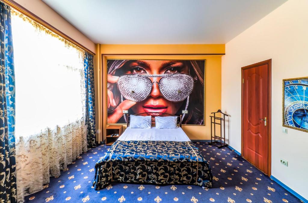 Dormitorio con póster de una mujer con gafas de sol en Apartment & Guest Rooms ART Bukhta, en Sevastopol