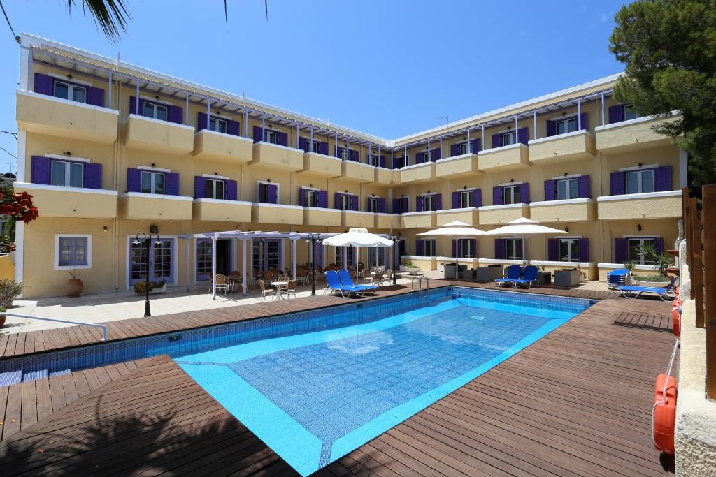 um hotel com piscina em frente a um edifício em Katerina Hotel em Agia Marina Aegina