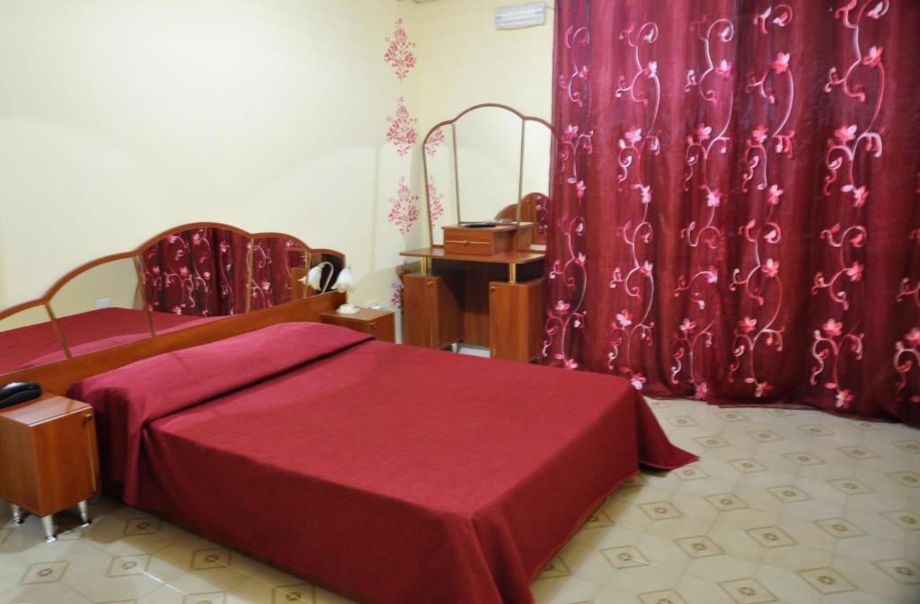 a bedroom with a red bed and red curtains at I 3 Pini in Cassino