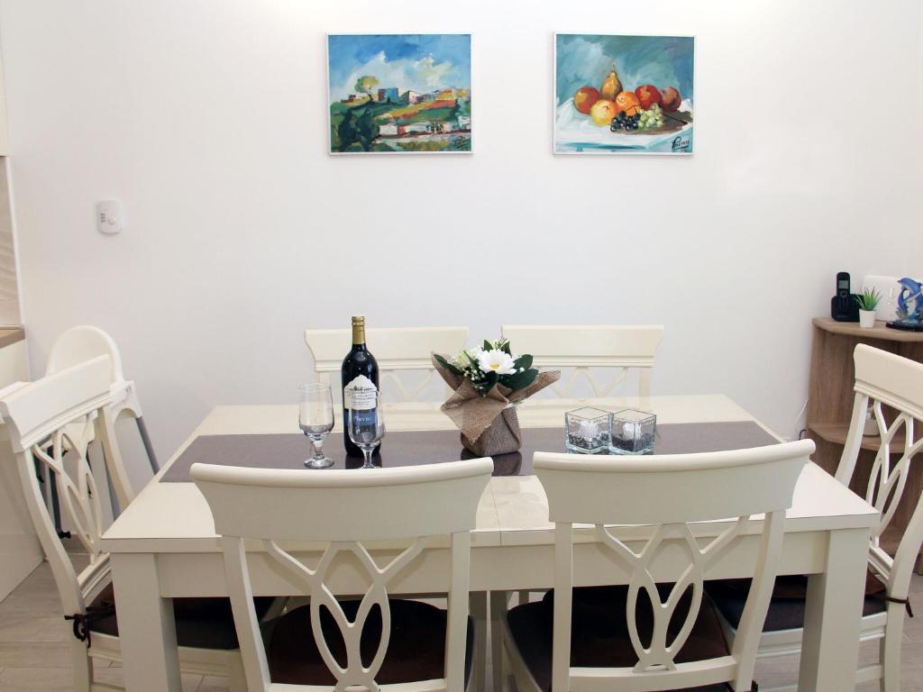 uma sala de jantar com uma mesa branca e cadeiras brancas em Charming Apartment in Greba tica with Terrace em Grebaštica
