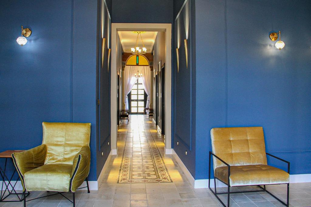 korytarz z dwoma krzesłami i niebieskimi ścianami w obiekcie Jaffo Tel-Aviv King Gallery Boutique Hotel w Tel Awiwie