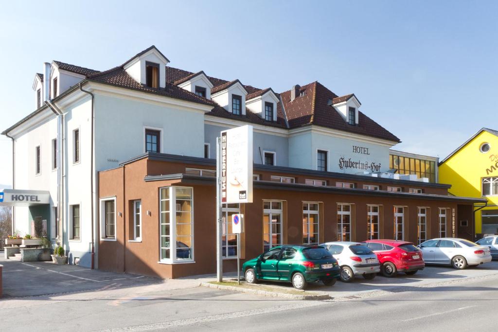 a building with cars parked in a parking lot at Hubertushof Self-Check-In in Zeltweg