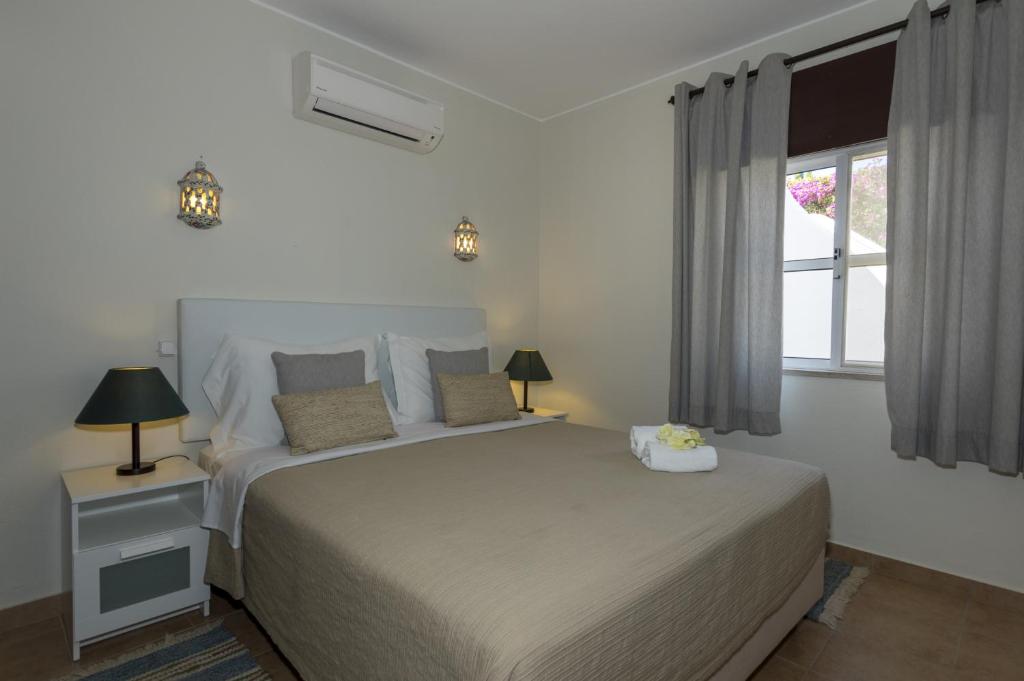 a bedroom with a large bed and a window at Rocha Brava Village Resort in Carvoeiro