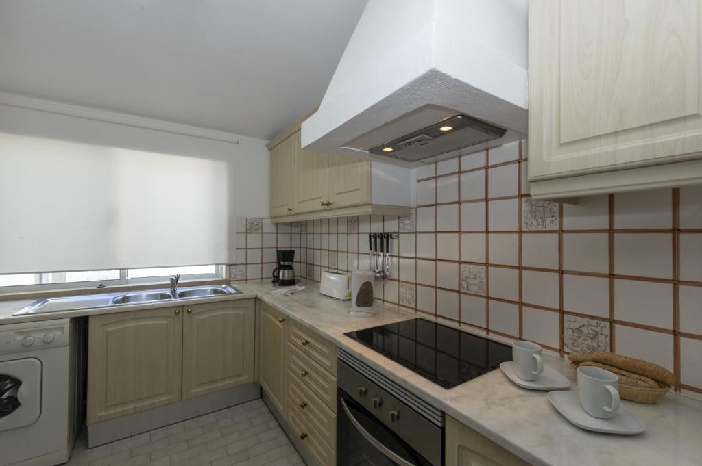 a kitchen with a sink and a stove at Rocha Brava Village Resort in Carvoeiro