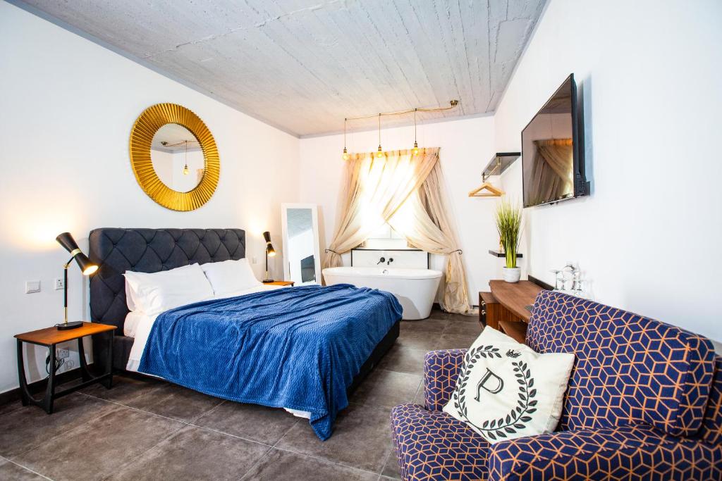 1 dormitorio con 1 cama y 1 silla en Pjazza Suites Boutique Hotel by CX Collection, en Siġġiewi