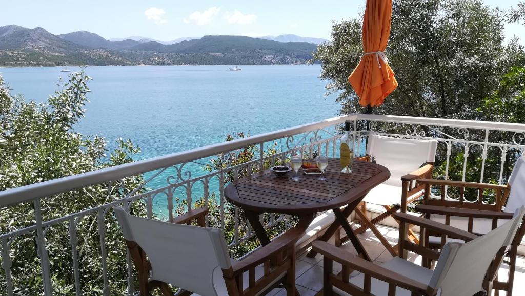 una mesa y sillas en un balcón con vistas al agua en Tzeni Villa, en Ligia