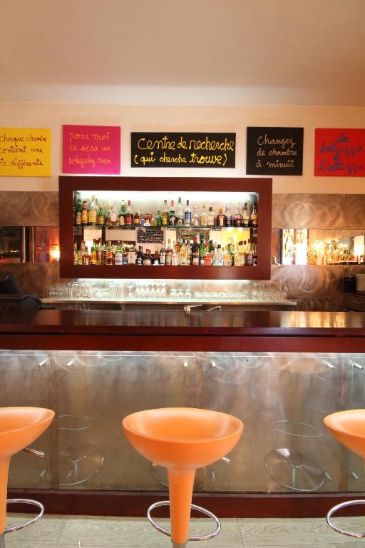 a bar with orange stools in a restaurant at Le Windsor, Jungle Art Hotel in Nice