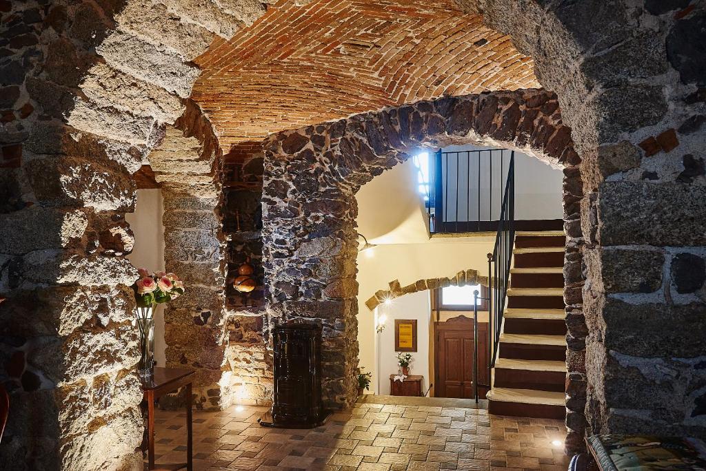 une arche dans un bâtiment en pierre avec un escalier dans l'établissement La casa del Balivo, à Dorgali