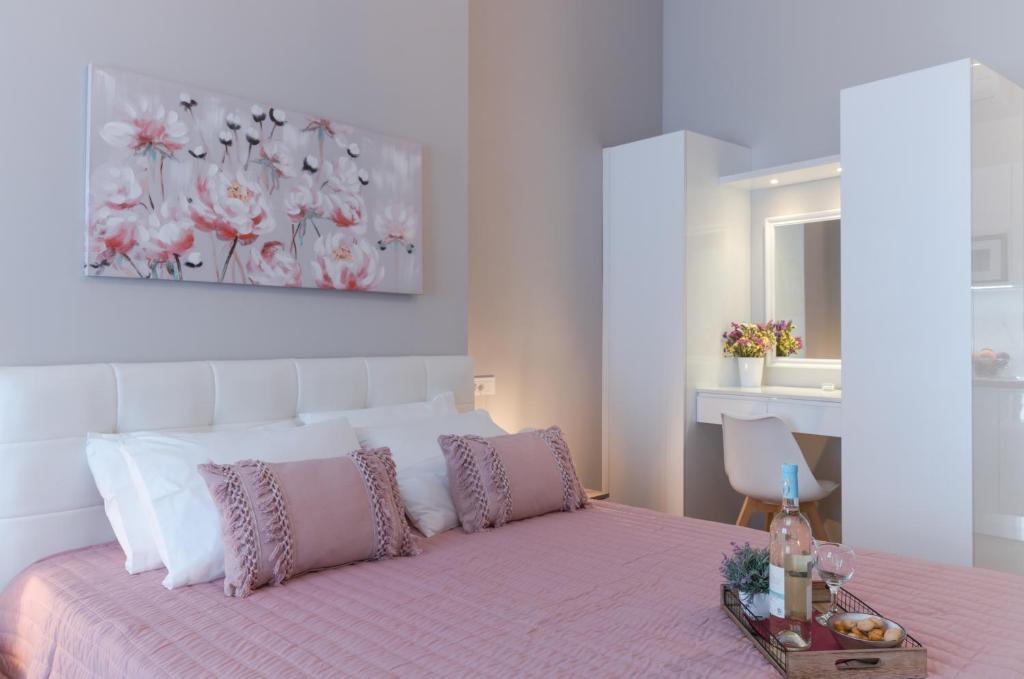 a bedroom with a bed with a pink bedspread at Saint George unique studio in Nafplio