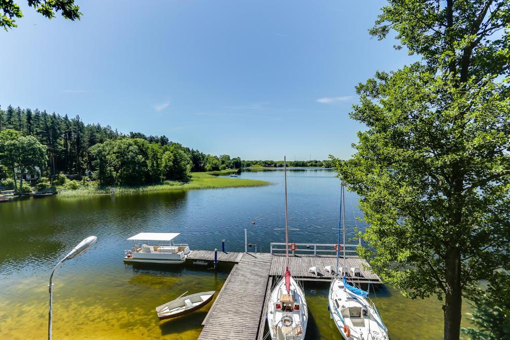 a dock with boats docked on a lake at Wyspa Brzozowa in Kretowiny