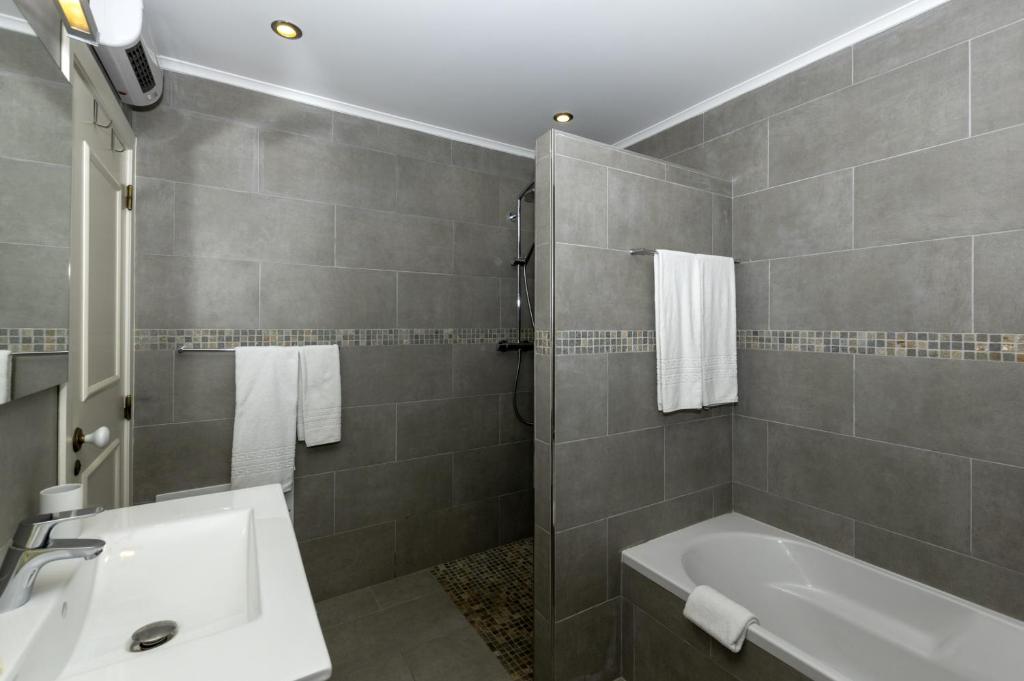 a bathroom with a sink and a bath tub at Rocha Brava Village Resort in Carvoeiro