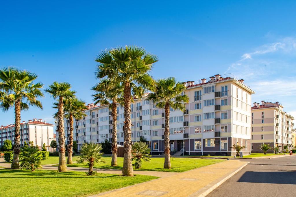 a row of palm trees in front of a building at Barkhatnye Sezony Sportivny Kvartal Resort in Adler